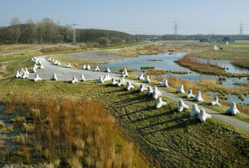 
     <i>Wellenbrecher (Wave Breaker)</i>, 
     2016<br />
     Installation in public space, Emscherkunst Triennial, 2016, 
      60 concrete tetrapods (2,20 × 2,20 × 2,20 m each, 6 tonnes)  all over installation 130 × 20 m​​<br />
     The installation 'Wave-Breaker' metaphorically recreates the imprint of Noah’s Ark on the grounds of the detention basin. The imprint was apparently discovered by a pilot near Turkey’s Mount Ararat in 1960. To create the monumental and segmented sculpture, the artist uses 60 wave-breaker (breakwaters) in the form of concrete tetrapod blocks, each measuring over two metres. These are used in the hydraulic engineering industry to protect coasts and banks and are usually found in coastal areas. Thus, she makes direct reference to the place and its protective function: After its completion, the detention basin will be utilized for absorbing flood waves in the case of heavy rainfall. The Wave-Breaker refer to both Noah’s Ark and the hope of a new beginning after a catastrophe caused by either climate change as well as how these are ingrained in the memory of humankind and are still being discussed today in the context of the plight of refugees. The question arises of who are the chosen ones, who are allowed to enter the boat? Wave-Breaker also symbolically stands for the breaking of political trends/ waves, most of all nationalist ideologies. (excerpt from a text by Lisa Maria Weber and Leonie Böhmer)