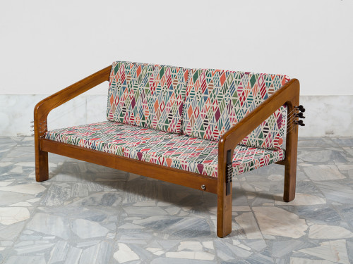 
     <i>Couch Flamenco Guitar and Mandolin (from the series Music Room, Athens)</i>, 
     2017<br />
     Wood, Flamenco strings and mechanism on one side oak frame the couch and mandolin mechanism on the other side, amplification option, 
      61 x 127 x 68 cm<br />
     