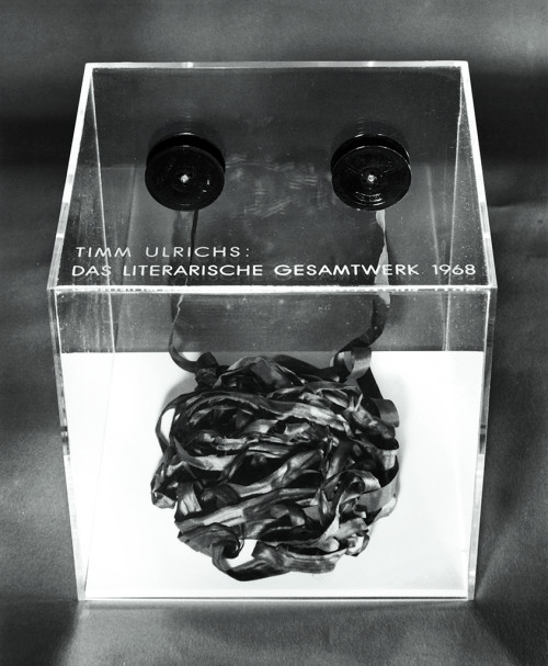 
     <i>Das literarische Gesamtwerk 1968, Band I</i>, 
     1968<br />
     typewriter tape, acrylglas case, 
      1.3 x 1000 cm (tape), 25 x 25 x 25 cm (case)<br />
     